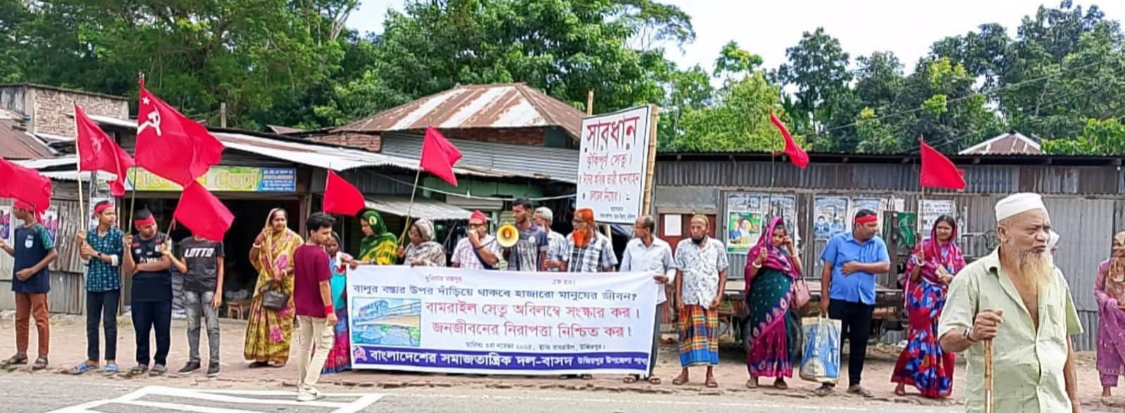 বালুর বস্তায় জোড়াতালি দেয়া সেতু নির্মানের দাবীতে মহাসড়ক অবরোধ 